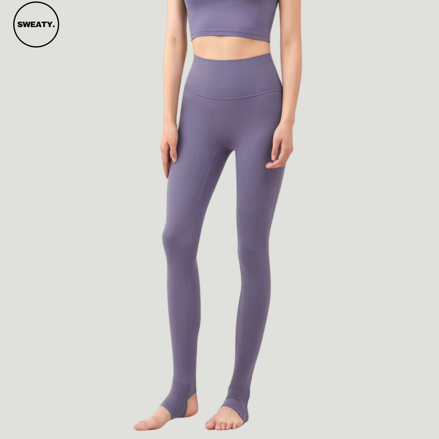 Model wearing Amethyst Breathable Stirrup Yoga Leggings by SWEATY, designed for ultimate comfort and flexibility. The leggings feature a high-waisted design and stirrup straps for secure fit during yoga and other fitness activities. The amethyst color highlights style while maintaining functionality.