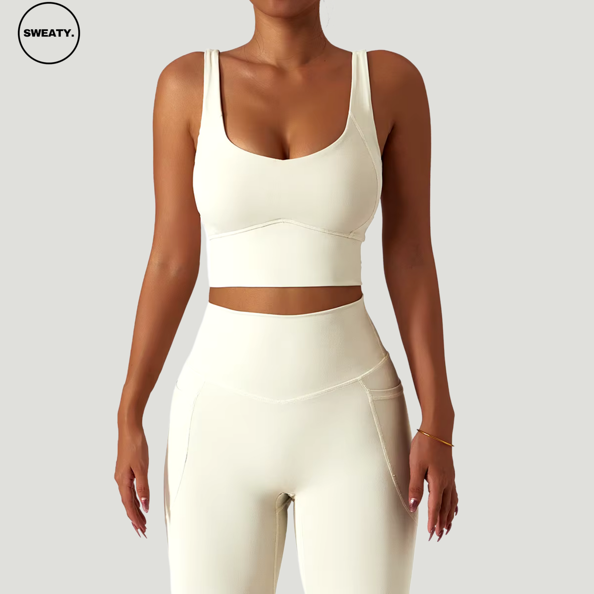 Front view of a woman wearing the apricot-colored seamless tracksuit set from SWEATY, featuring a fitted sports bra and high-waisted leggings for ultimate comfort and performance.