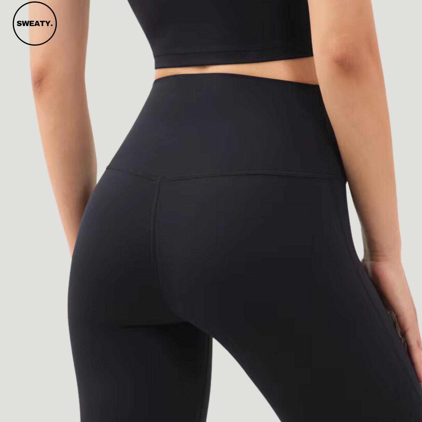 Back view of Black Breathable Stirrup Yoga Leggings by SWEATY, showcasing the high-rise waistband and contoured fit. These leggings offer full coverage and support, with breathable fabric ideal for movement-focused activities.