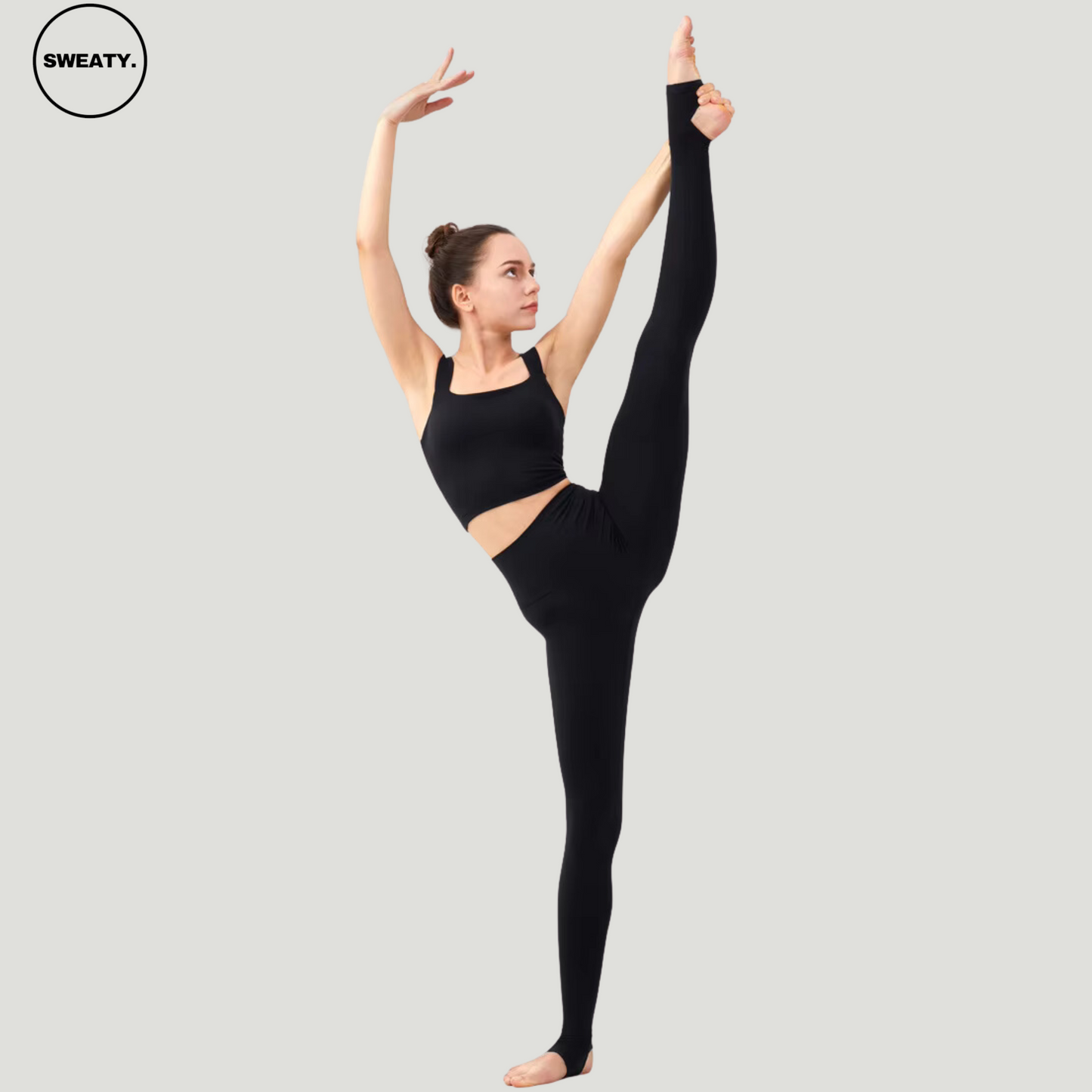 Model wearing Black Breathable Stirrup Yoga Leggings by SWEATY, demonstrating an extended leg stretch. The high-waisted leggings provide flexibility and a secure fit with stirrup detailing, perfect for active movements and yoga poses.