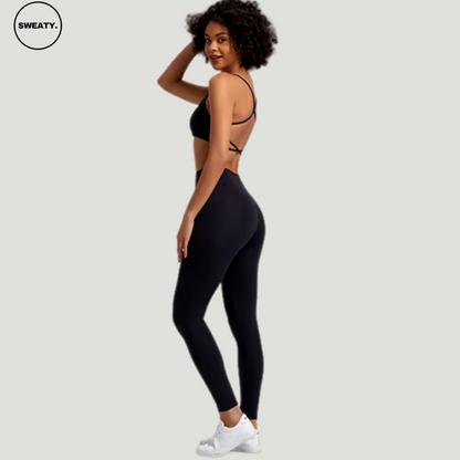 Black-Buttery-Soft-Gym-Set-Side-View-by-SWEATY - Women's bold and vibrant black-buttering leggings and sports bra, featuring an elegant cross-back design for enhanced support and style during fitness activities. Perfect for those looking to stand out in the gym with both color and performance.