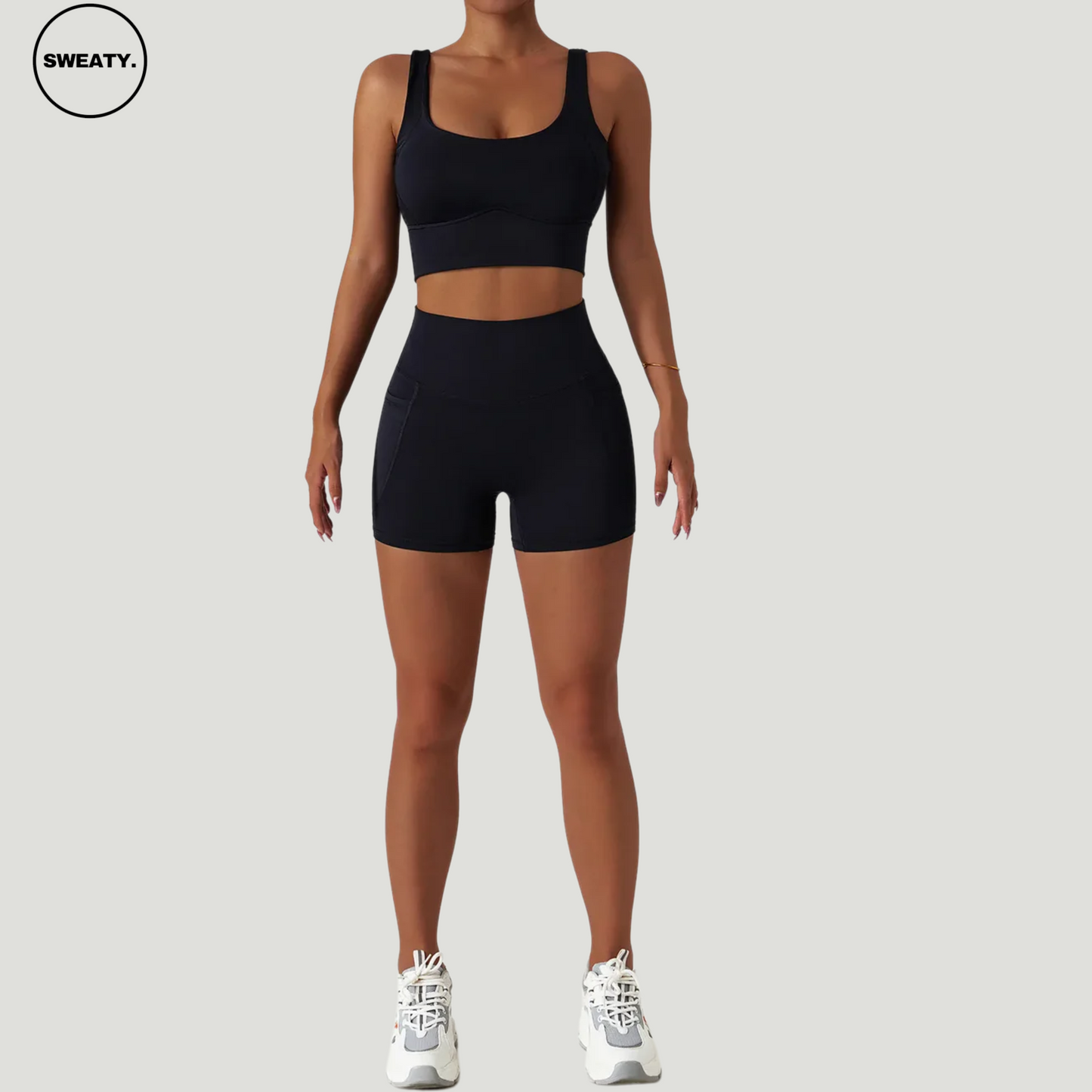 Front view of the black seamless tracksuit set by SWEATY. A women's black fitness outfit featuring moisture-wicking, breathable fabric ideal for yoga, running, and fitness. Includes high-waisted black shorts and a supportive black sports bra for optimal comfort during workouts.