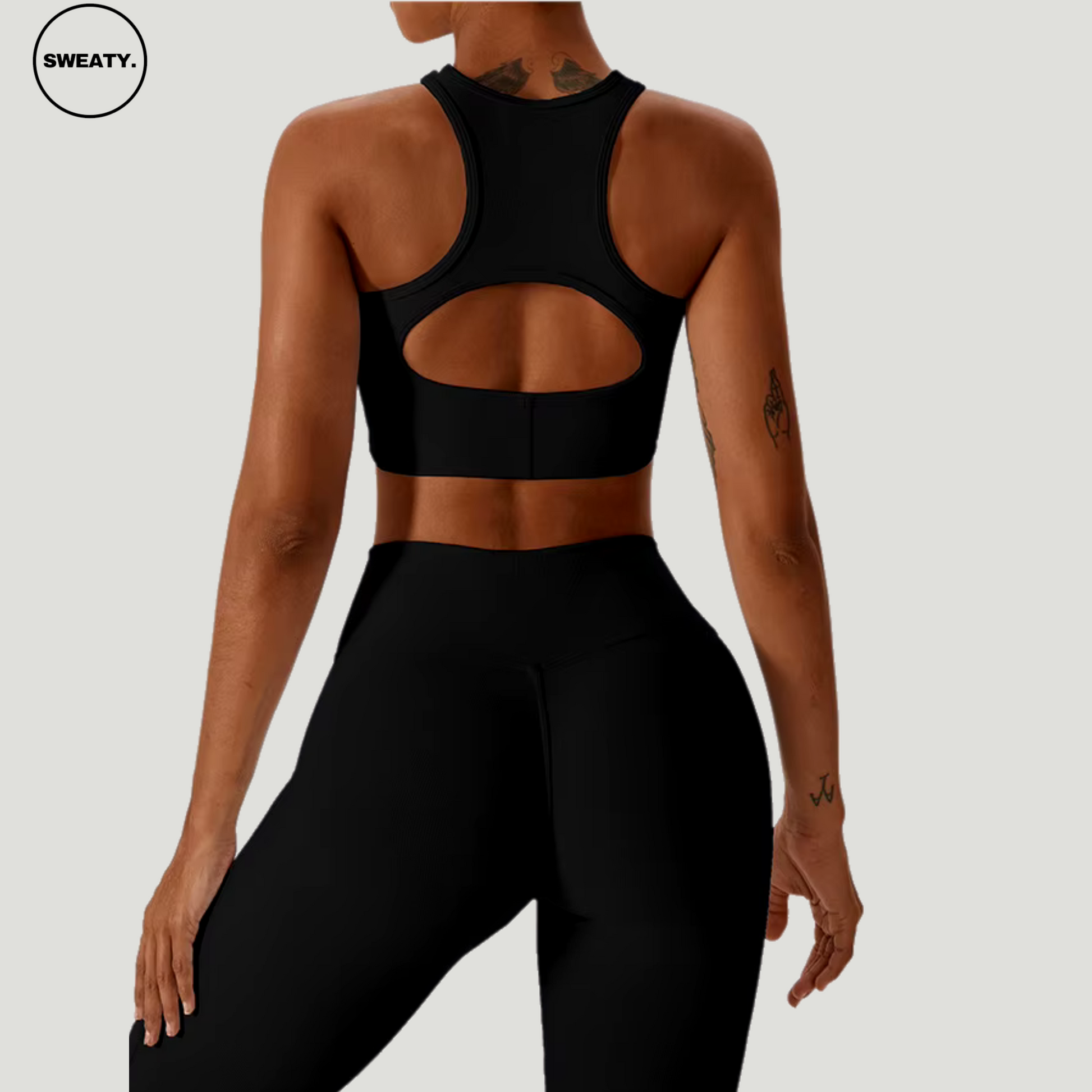 Black seamless sportswear set by SWEATY – back view featuring open-cut sports bra and high-waisted leggings. Made from breathable, quick-dry fabric, perfect for yoga and fitness.