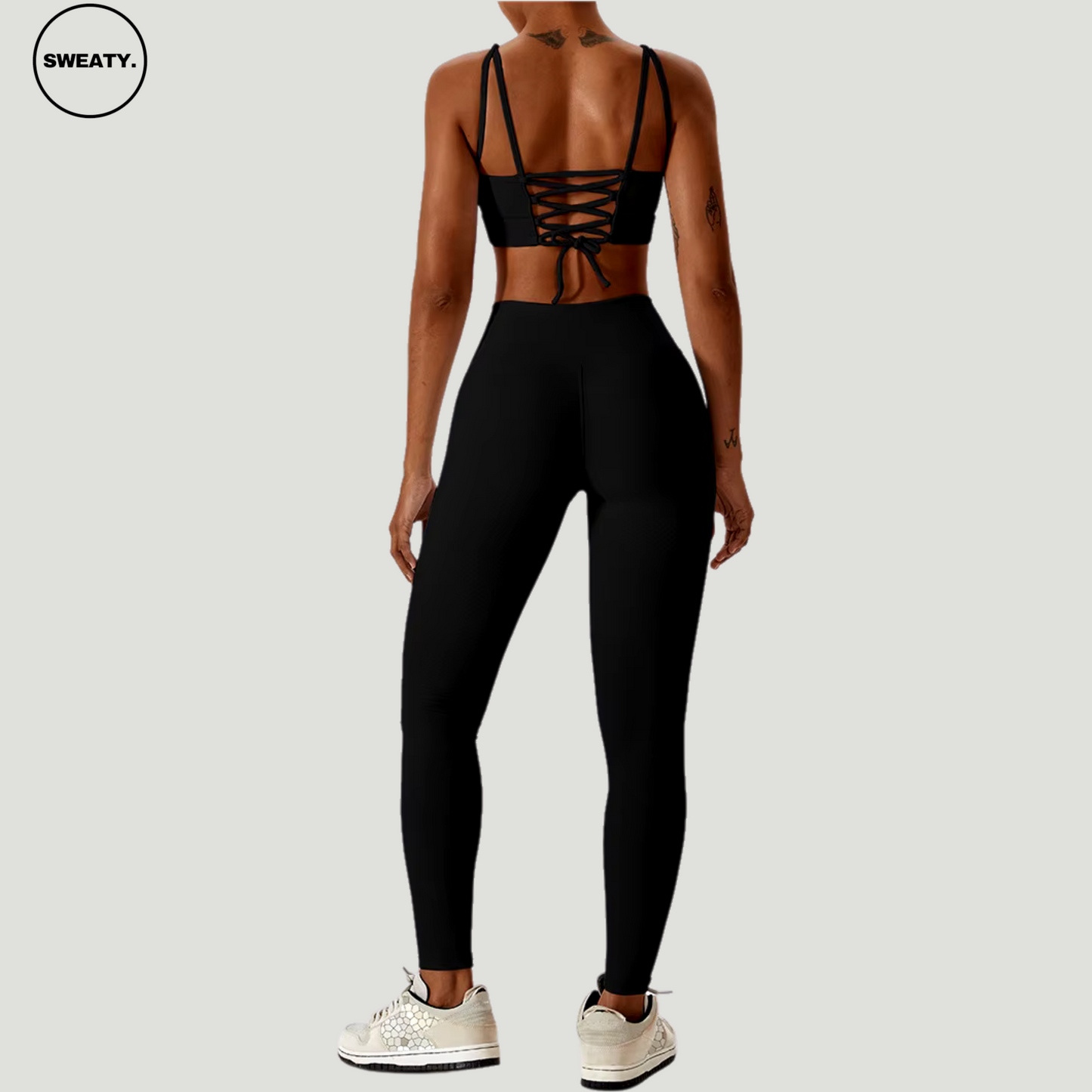 Black seamless sportswear set by SWEATY – back view showcasing the strappy sports bra and high-waisted leggings. Ideal for yoga, fitness, and running, featuring breathable and moisture-wicking fabric.