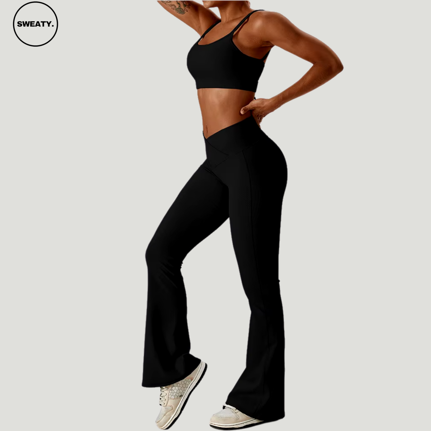 Black seamless sportswear set by SWEATY – side view of sports bra paired with flare leggings. Made with flexible and breathable material, perfect for yoga, gym, and running activities.