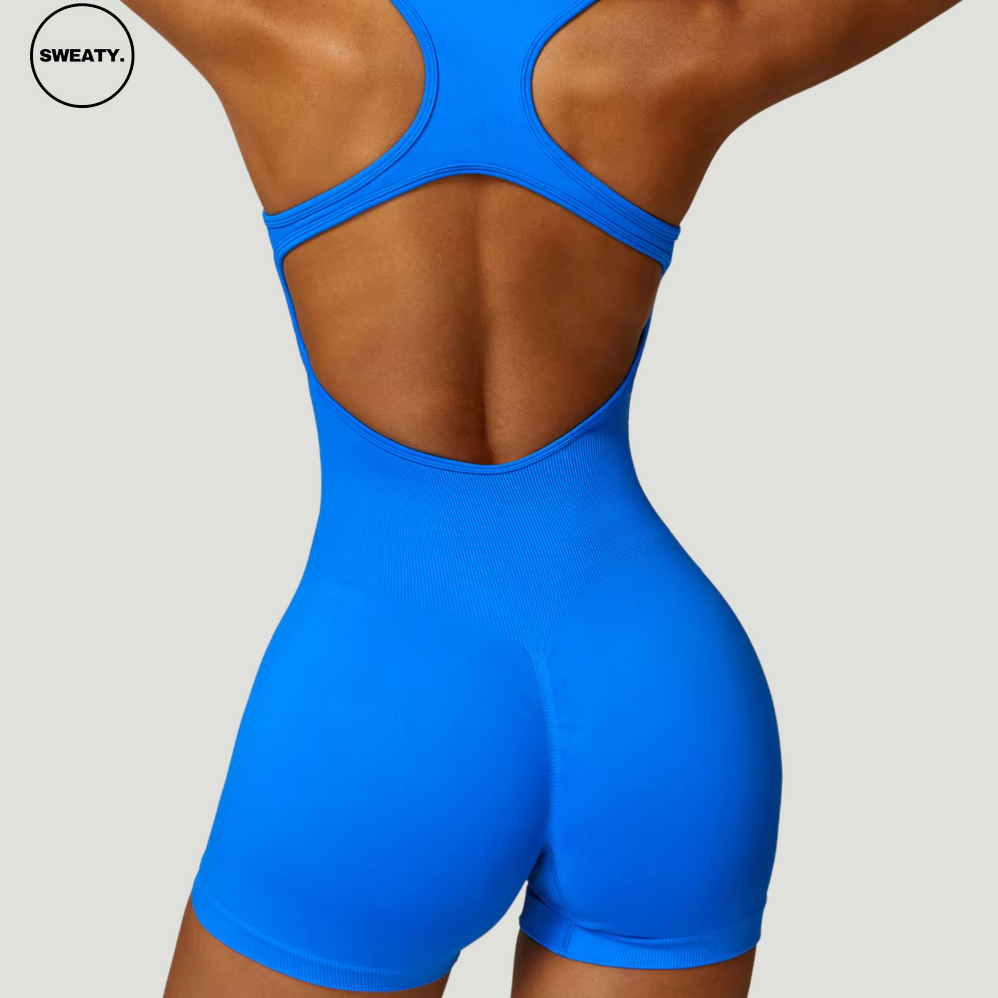 Blue seamless gym shortie jumpsuit by SWEATY - Women's full back view highlighting the open-back racerback design and high-performance fit. The seamless construction ensures flexibility and comfort during workouts or fitness activities.