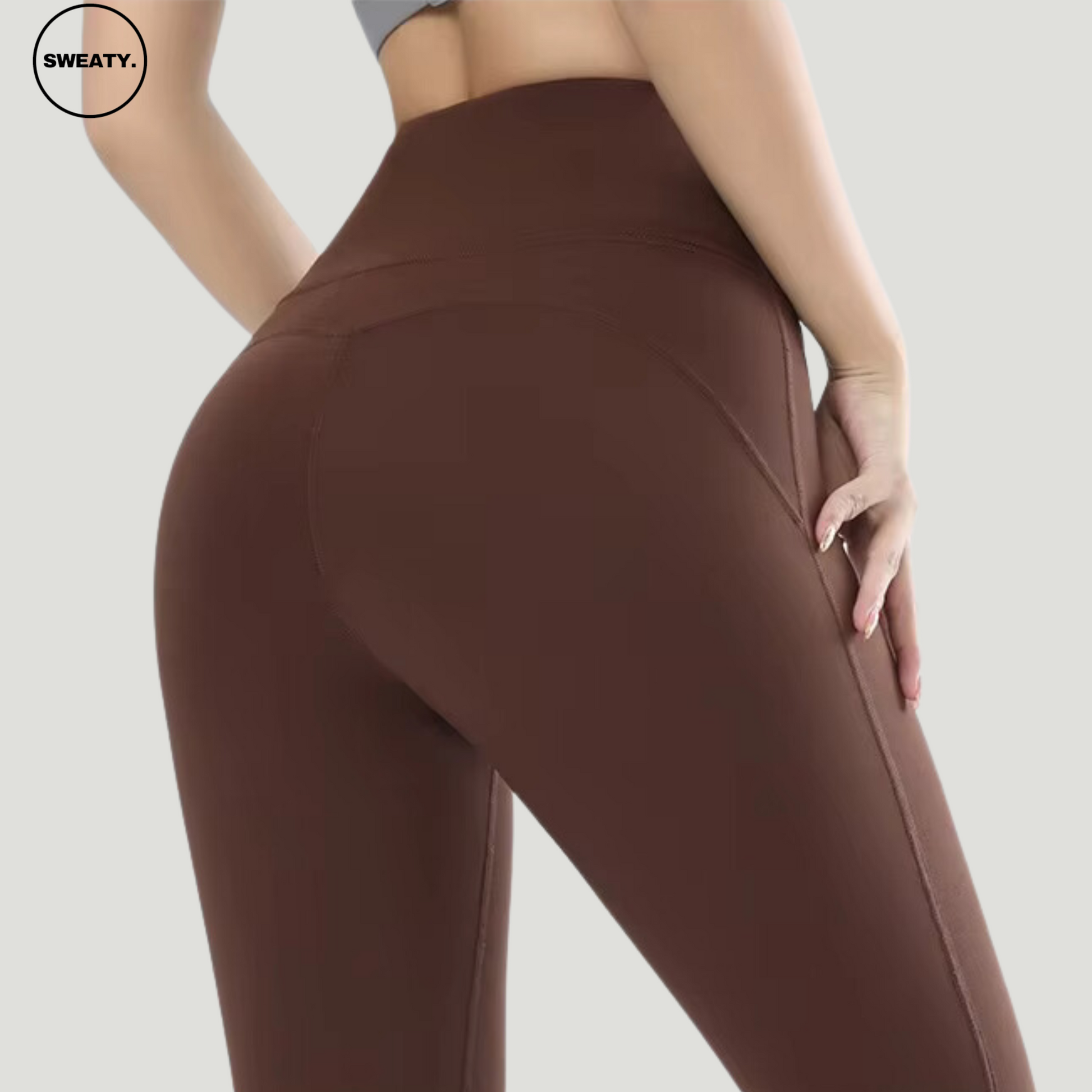 Close-up view of a model wearing Brown High Waist Slim Yoga Pants by SWEATY, highlighting the curve-enhancing fit and supportive high waistband. The soft fabric ensures a comfortable yet flattering look for both exercise and casual wear.