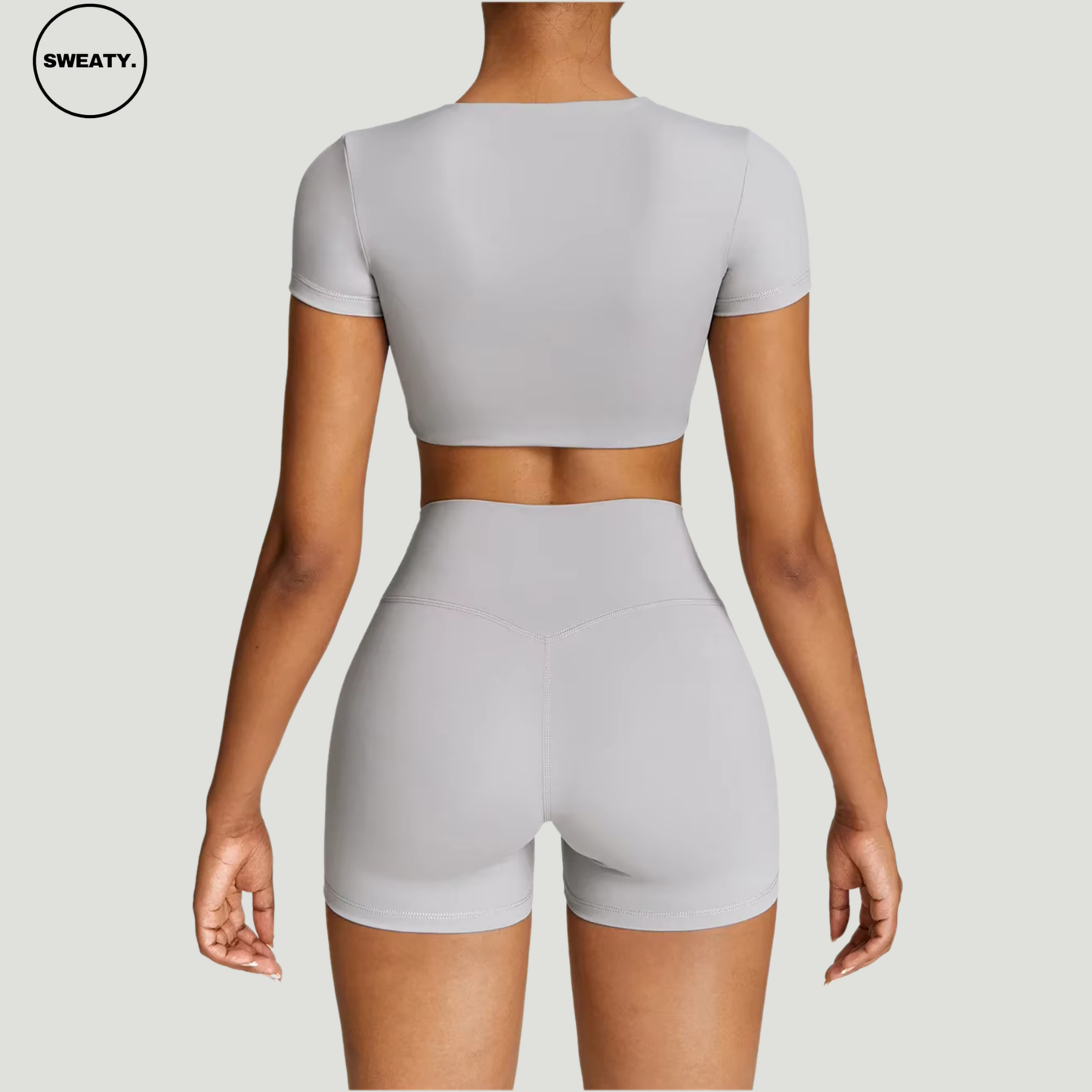 Frost Grey Yoga Set by SWEATY - Back view of the women's short-sleeve crop top and shorts, featuring moisture-wicking, breathable fabric. Designed for high-performance yoga and fitness activities.