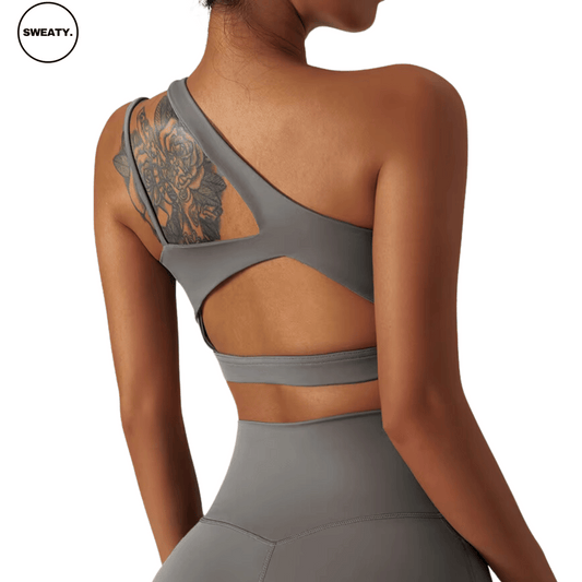 Back view of a gray Asymmetrical Double Strap Sports Bra by SWEATY, featuring a unique open-back design with dual straps and cut-out detailing, offering both style and breathability for high-performance workouts.