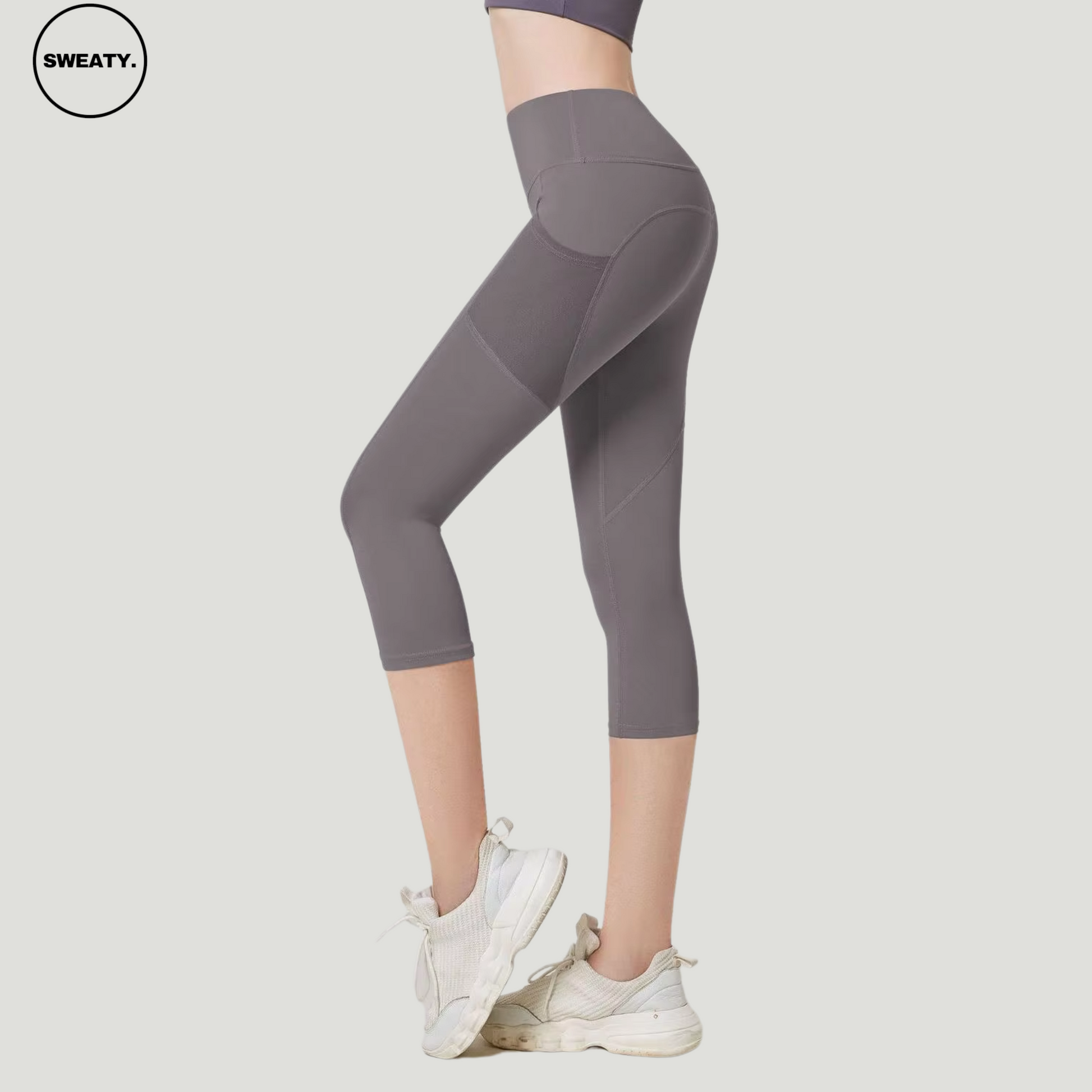 Gray High Waist Mesh Pocket Capri Pants by SWEATY, side view showcasing the mesh panel details and high-waisted design. These capri-length pants offer practicality with mesh pockets and a snug, form-fitting design, perfect for yoga and activewear.