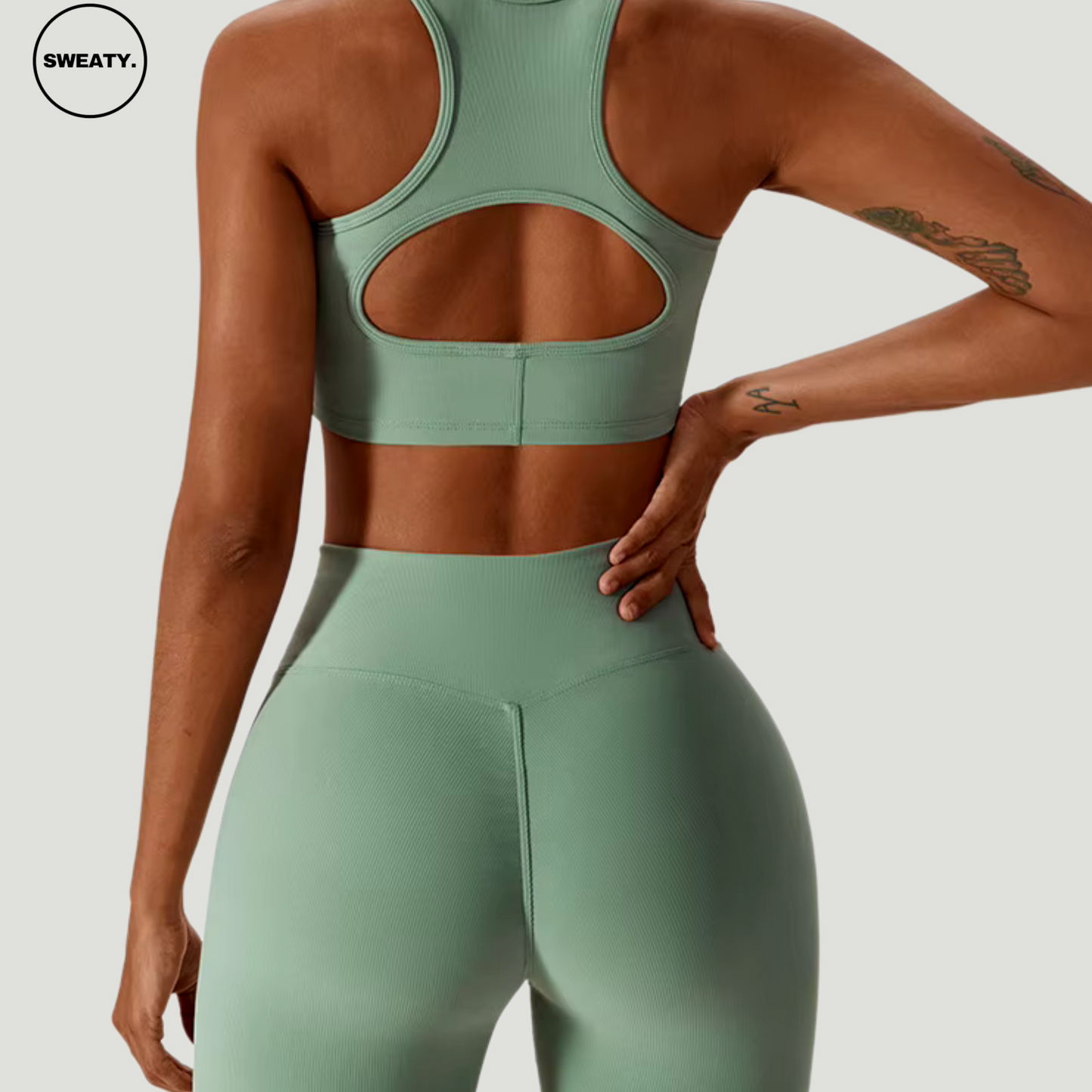 Green seamless sportswear set by SWEATY – back view highlighting the racerback cutout sports bra and high-waisted leggings. Made from flexible, moisture-wicking fabric, perfect for workouts and gym activities.