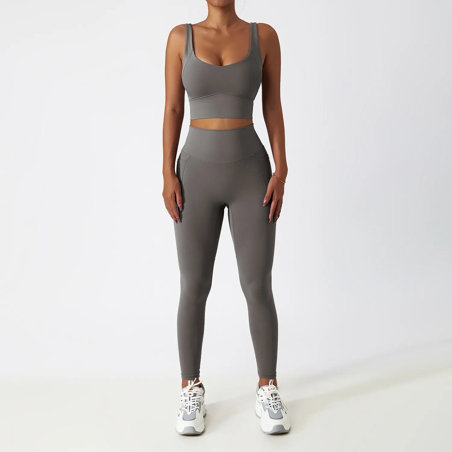 Grey seamless tracksuit set by SWEATY - Women's high-waist leggings and supportive sports bra made from breathable, moisture-wicking fabric. Ideal for yoga, running, and fitness, ensuring comfort and flexibility during workouts.