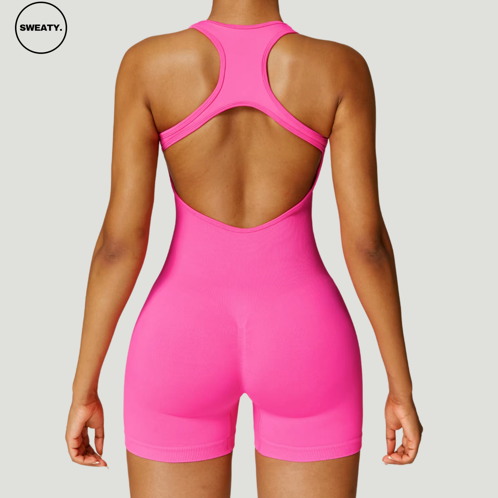 Hot pink seamless gym shortie jumpsuit by SWEATY - Women's back view highlighting the racerback and open-back design. This jumpsuit offers a comfortable, flexible fit, ideal for gym sessions and active workouts.