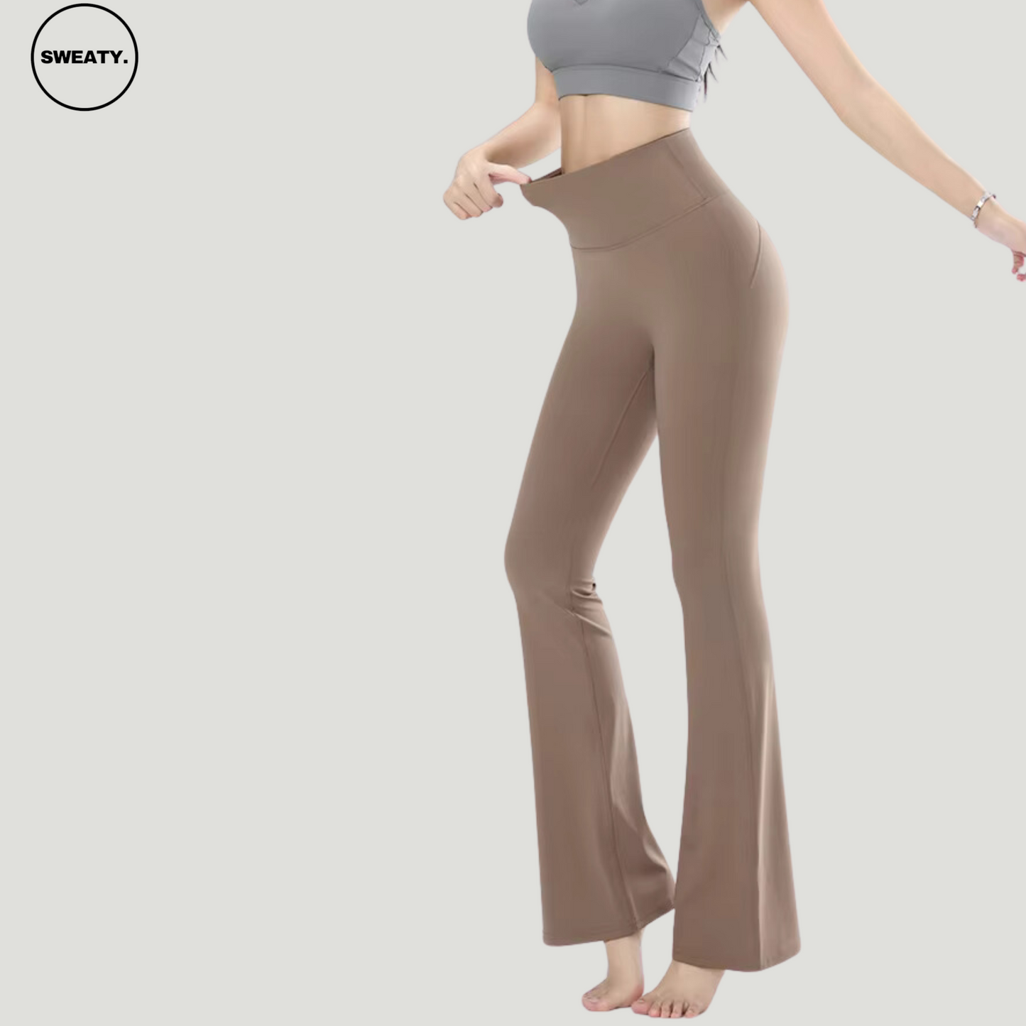 Khaki High Waist Slim Yoga Pants by SWEATY - Side view showing model stretching the high-rise waistband. Designed with flexible, soft fabric for maximum comfort and stretch, ideal for yoga, fitness, or casual wear. Flared leg design for a flattering fit.