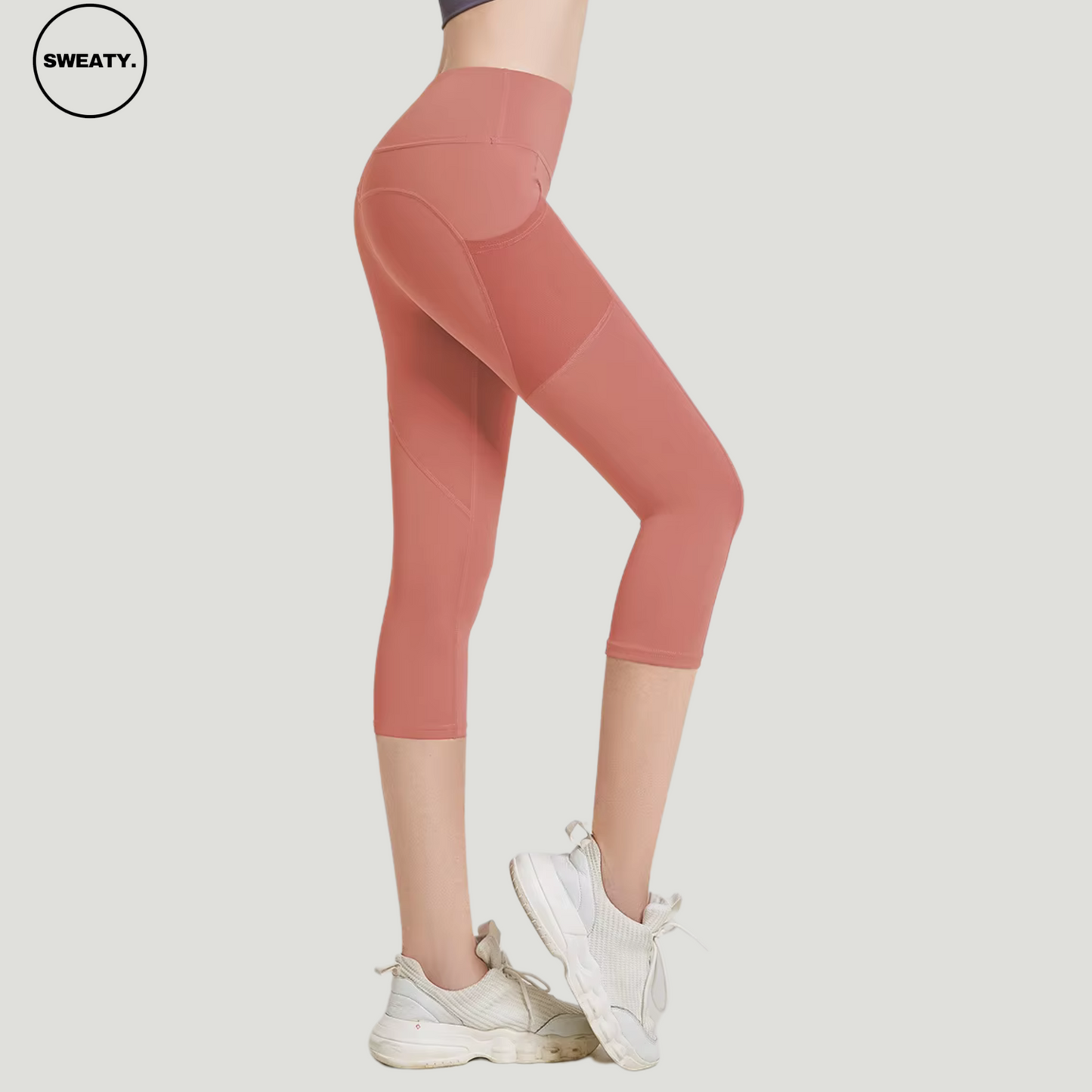 Light Pink High Waist Mesh Pocket Capri Pants by SWEATY, featuring mesh paneling and functional mesh pockets. These capri-length leggings are designed with a high-waisted fit, providing both style and comfort for yoga and athletic activities.