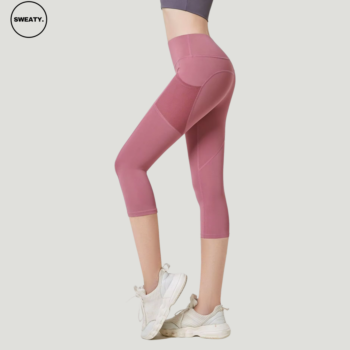 Pink High Waist Mesh Pocket Capri Pants by SWEATY, side view showing the mesh paneling and high-waisted design. These capri-length pants offer both functionality with mesh pockets and a flattering, snug fit, ideal for activewear and yoga.