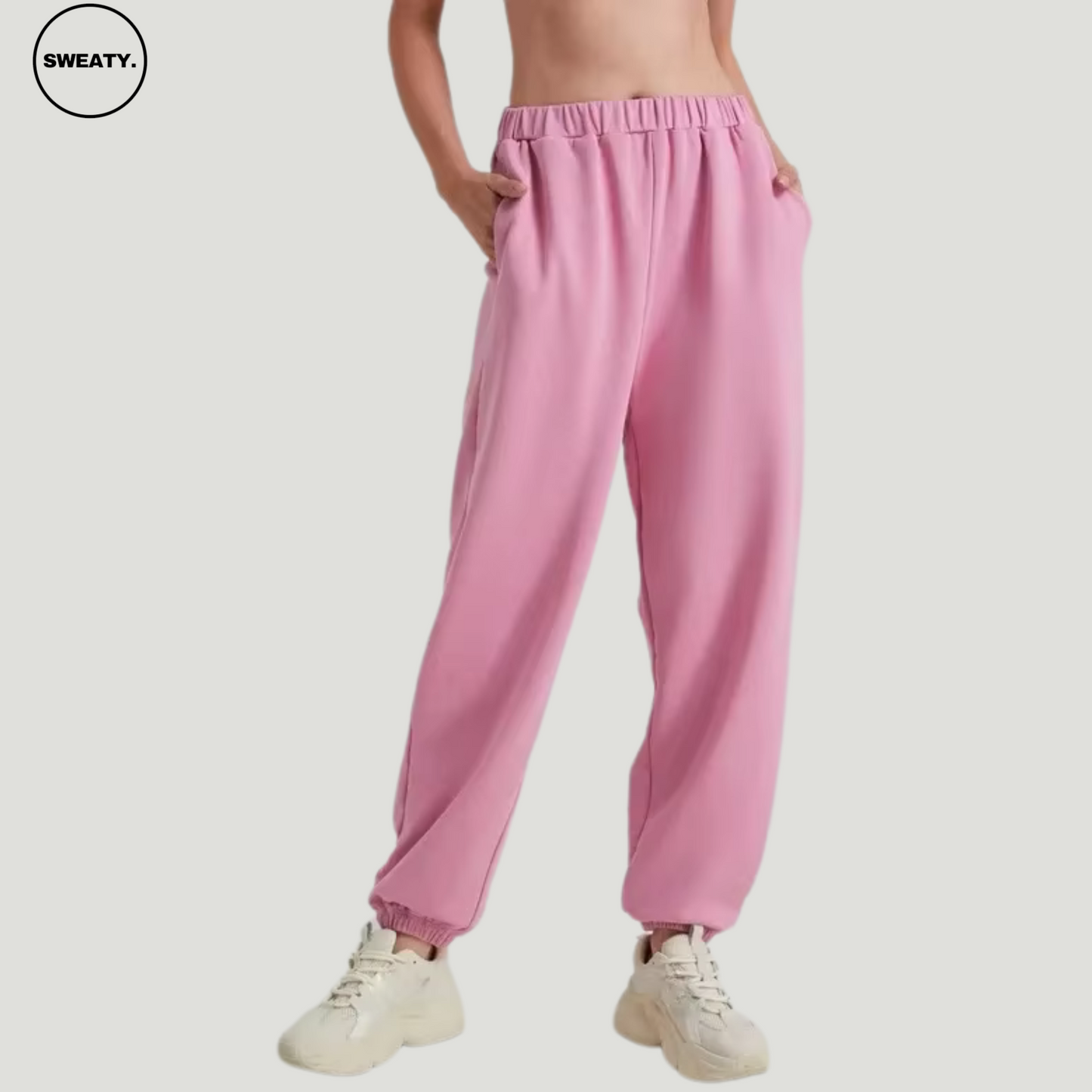 Pink wide-leg fleece-lined sweatpants by SWEATY - Women's relaxed-fit sweatpants with a soft fleece interior and side-front view. Designed for comfort, these pants feature an elastic waistband and pockets, perfect for casual wear or lounging.