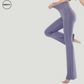 Side view of a model wearing Purple High Waist Slim Yoga Pants by SWEATY, highlighting the figure-flattering fit, high-rise waistband, and flared leg design. The material offers comfort and stretch, perfect for yoga and everyday activities.