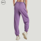 Purple wide-leg fleece-lined sweatpants by SWEATY - Women's back walking view showing relaxed fit and cuffed ankles. These cozy sweatpants feature a soft fleece interior, making them perfect for casual wear or lounging.