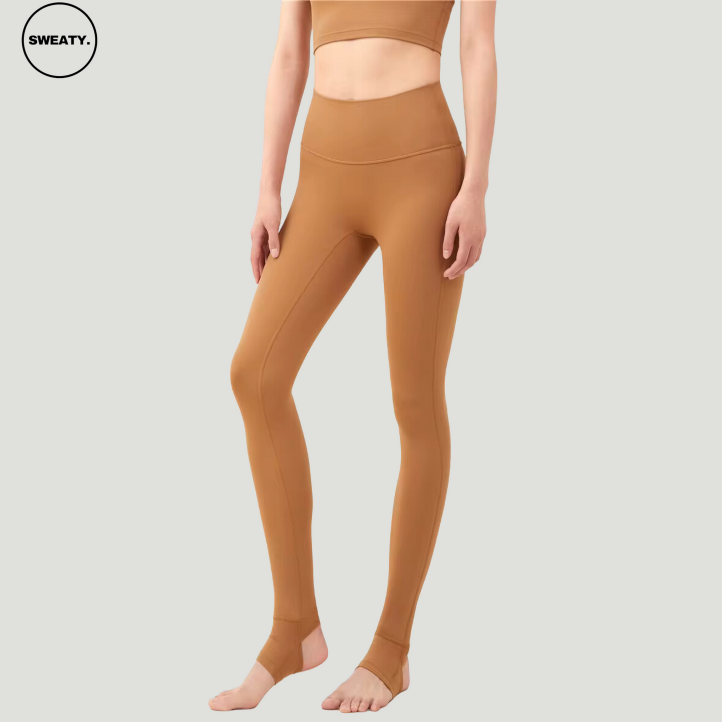 Side view of model wearing Saddle Breathable Stirrup Yoga Leggings by SWEATY. The leggings feature a streamlined design with a high-waisted fit and stirrups for added stability during workouts.