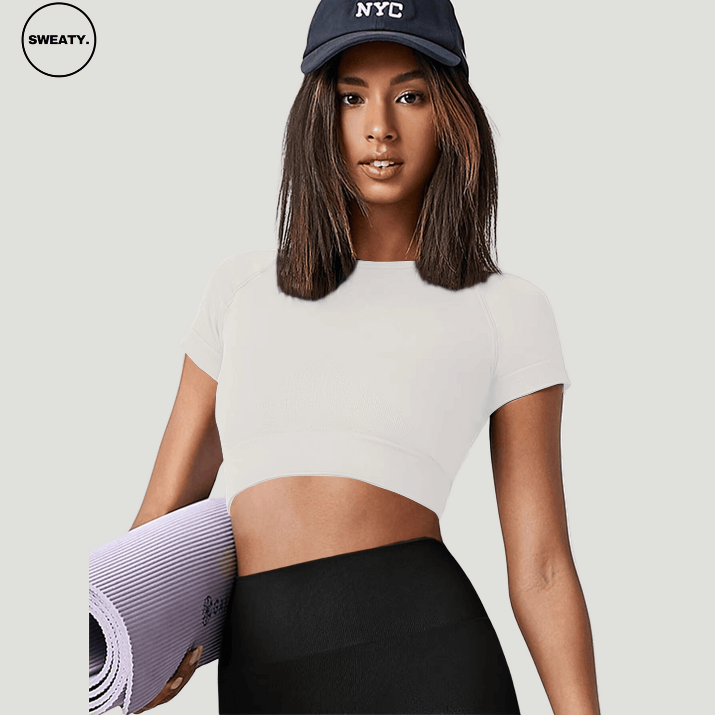 White Cropped Yoga Top by SWEATY - Women's fitted, moisture-wicking, and breathable crop top designed for yoga and fitness, paired with a casual cap. SWEATY activewear offers comfort and performance, ideal for active lifestyles, shown from the front angle.