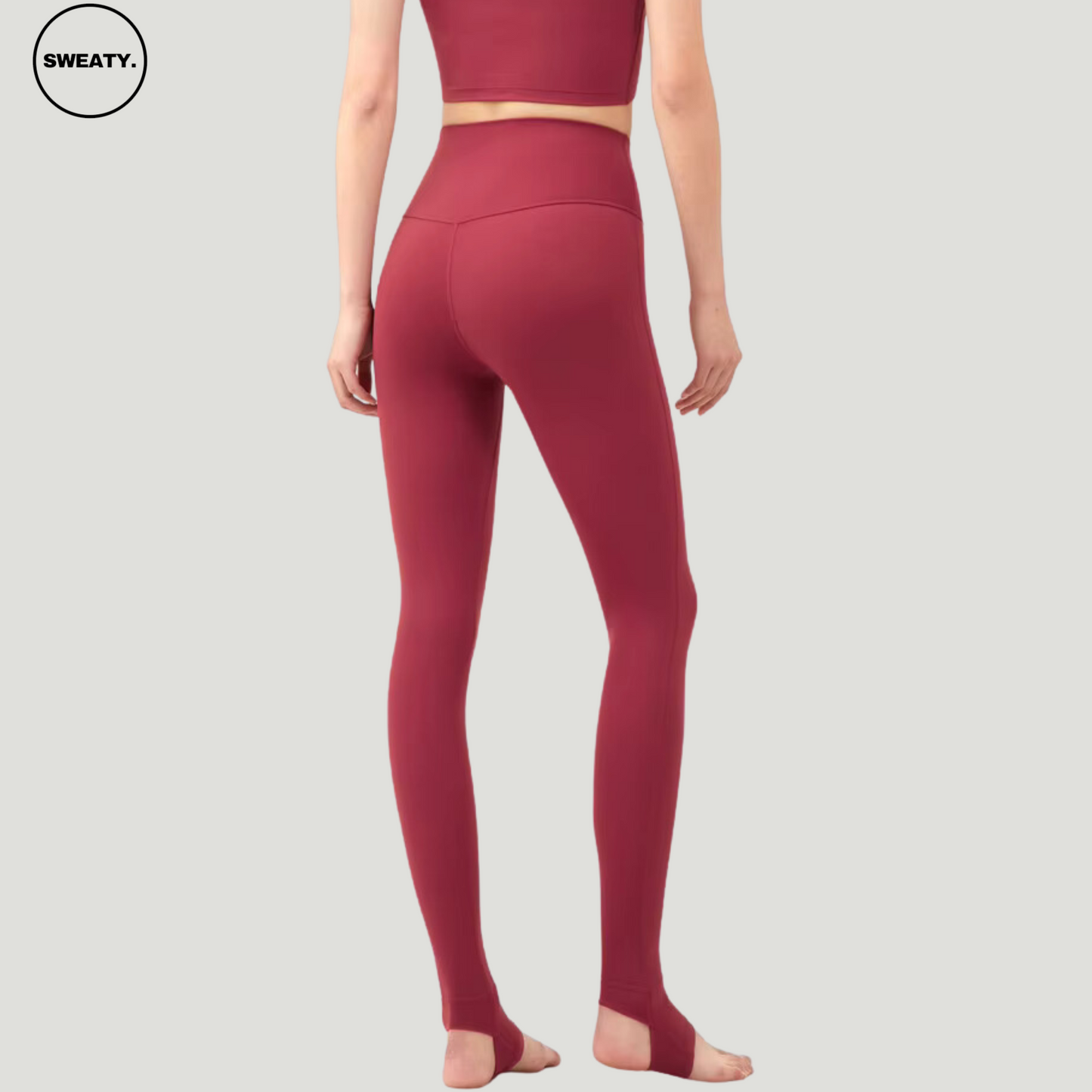 Back view of model wearing Wine Red Breathable Stirrup Yoga Leggings by SWEATY. These stirrup leggings provide a snug, supportive fit, enhancing flexibility and movement, ideal for yoga and dance.