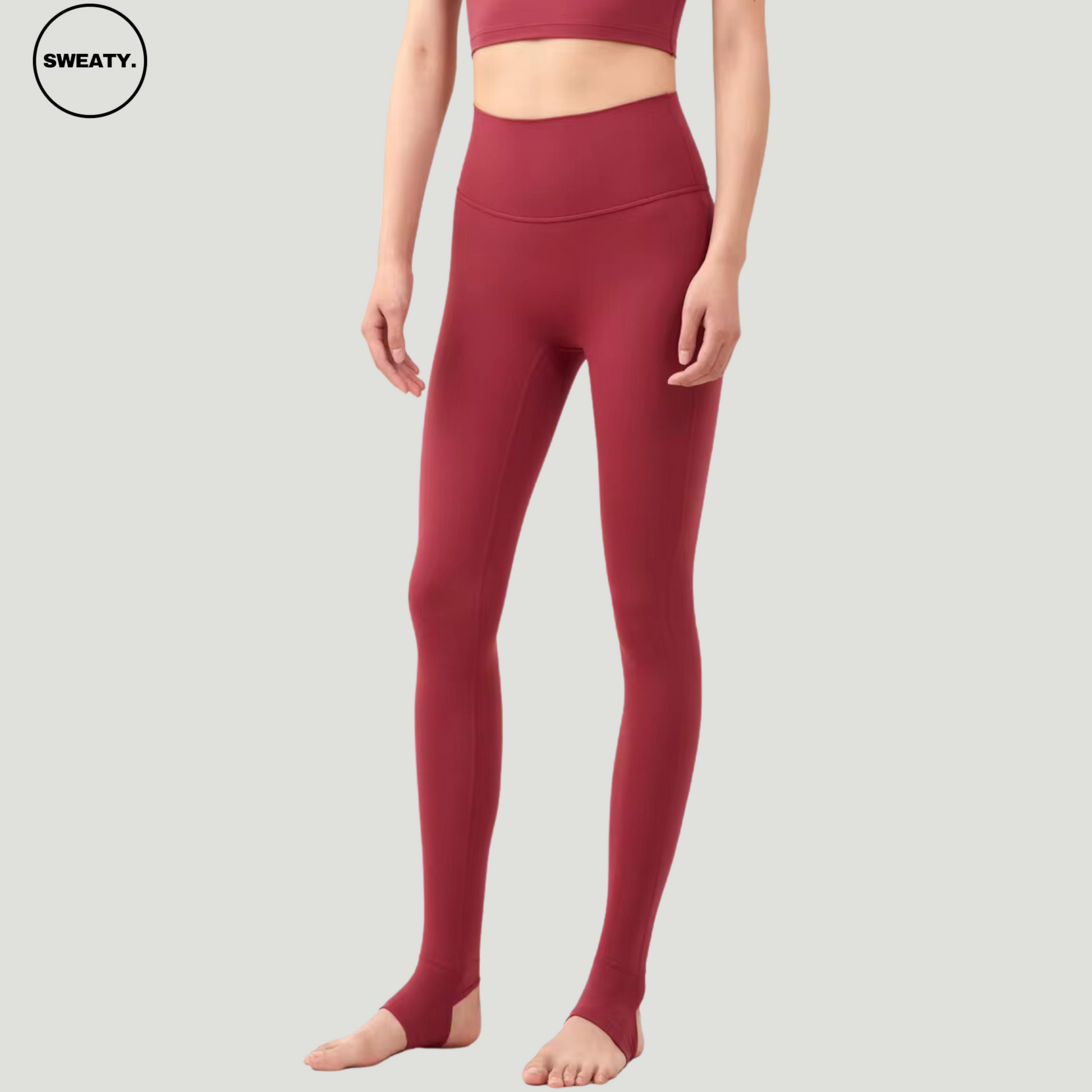 Model wearing Wine Red Breathable Stirrup Yoga Leggings by SWEATY. The high-waisted, stirrup design ensures a comfortable and secure fit, ideal for yoga, pilates, and other stretch-based workouts.