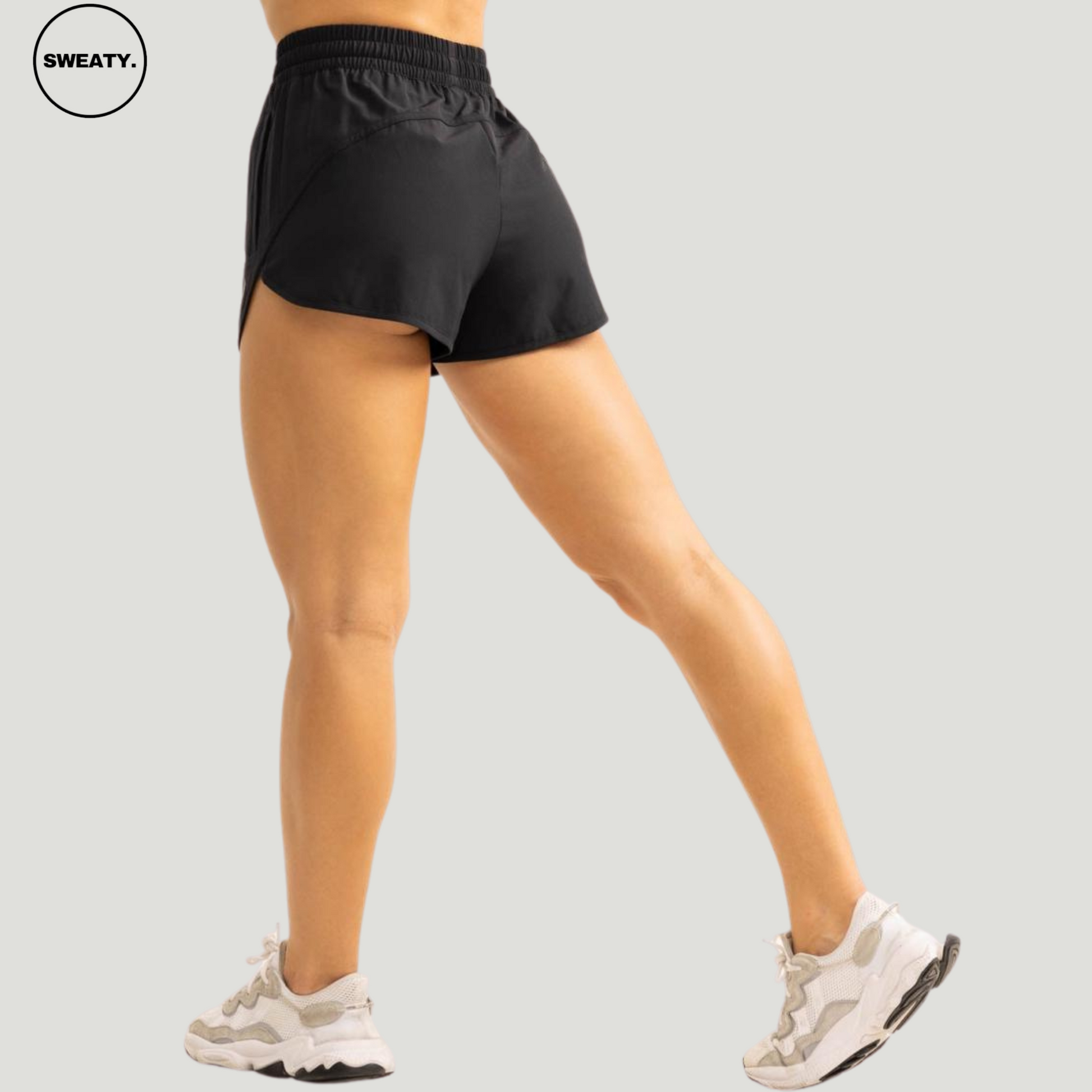 Back view of a woman wearing a black 2-in-1 skort from SWEATY, highlighting the flexible fit and design that offers coverage with the inner compression shorts for added support during workouts.