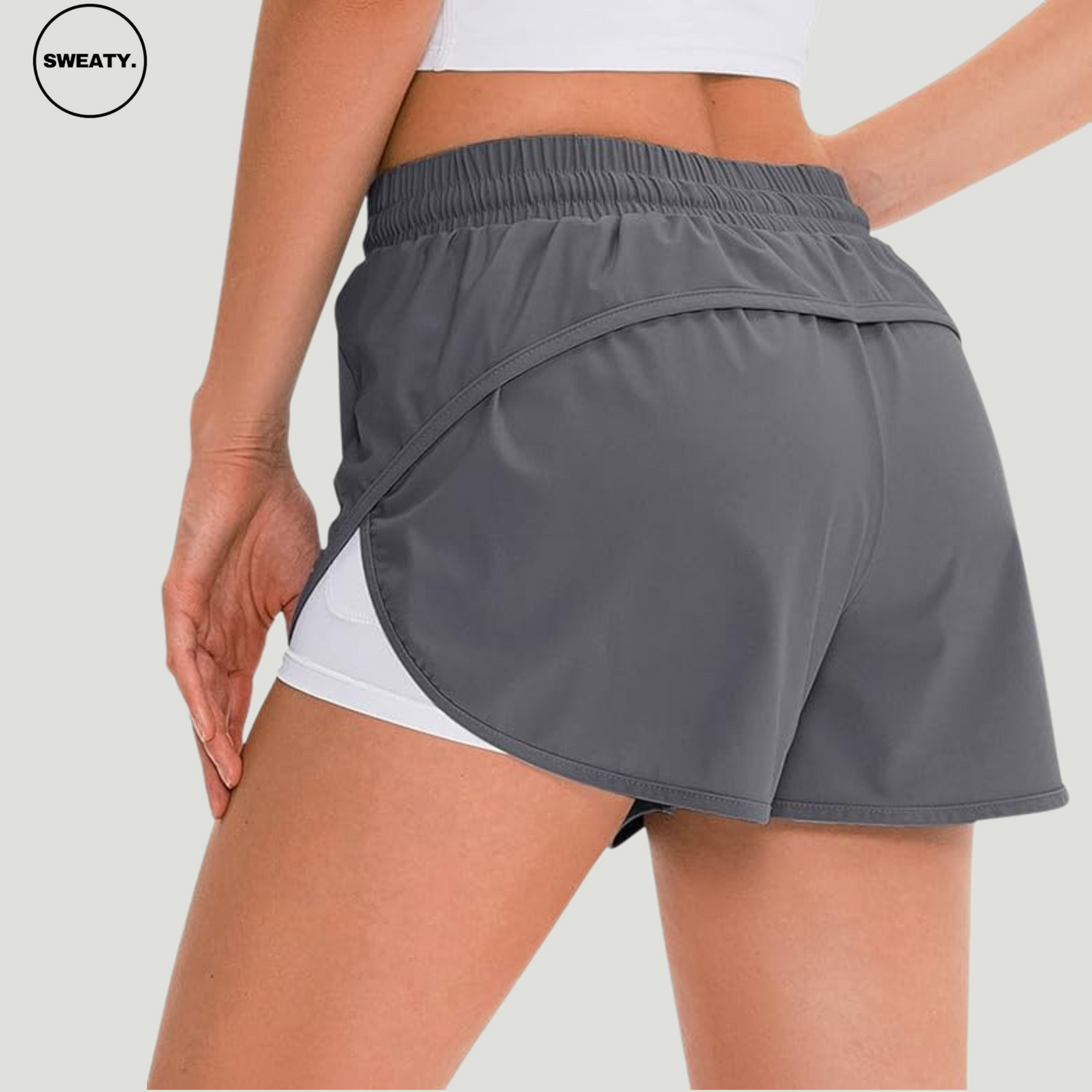 Back view of a gray 2-in-1 skort from SWEATY, highlighting the layered wrap-around design with elastic waistband and inner shorts for secure fit and movement during workouts.