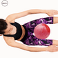 Woman performing ab exercises using a pink and red marble Pilates yoga ball from SWEATY, holding the ball between her legs while reaching forward, focusing on core strength and balance.